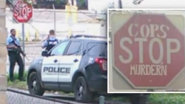 Residents Outraged After Watching Police Pose for Disturbing Photos by "Cops Stop Murdering" Sign