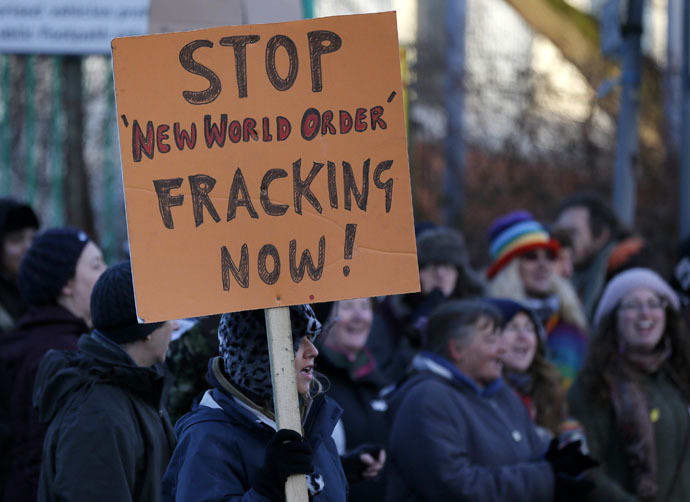 A demonstrator holds a placard in front of a police cordon outside the entrance to the IGas Energy exploratory gas drilling site at Barton Moss near Manchester in northern England January 13, 2014. (Reuters/Phil Noble)