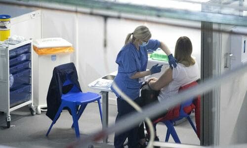 A nurse administers a Covid-19 vaccine to a health and care staff member at the NHS Louisa Jordan Hospital in Glasgow, Scotland, on Jan. 23, 2021. (Jane Barlow/PA)