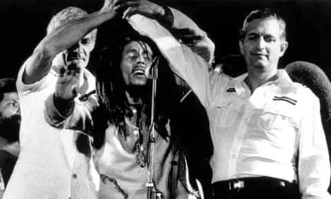 Edward Seaga, right, clasping hands with Michael Manley, left, and Bob Marley during the One Love concert at the national stadium in Kingston, Jamaica, on April 22, 1978. [Source: theguardian.com]
