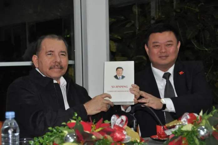 Daniel Ortega holding up a portrait of Xi Jinping with Wang Jing, a billionaire intent on funding a Nicaraguan canal. [Source: primerinforme.com]