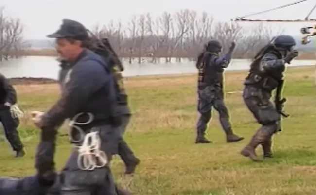 The ATF agents on the right are walking backwards with their hands raised after they ran out of ammo and were forced to negotiate an effective surrender/truce. If the Davidians REALLY opened fire on them first, why would they let them leave?