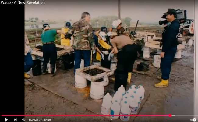 The scene was declared a “bio-hazard,” and since the FBI pre-determined that it was a “mass suicide,” the crime scene investigators were instructed to “sift, wash and bleach the evidence,” which they can be seen doing in this still from Waco- A New Revelation