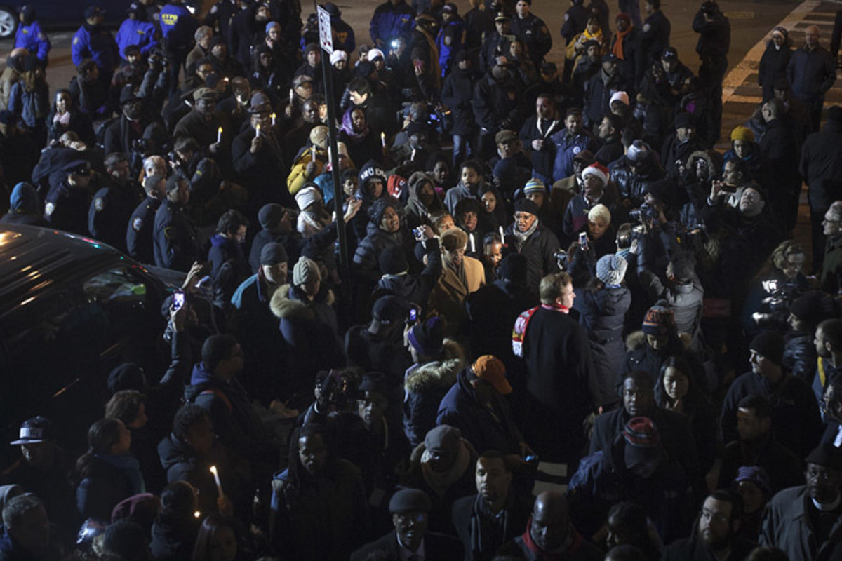 People take part in a candle light vigil at the site where two police officers were shot in the head in the Brooklyn borough of New York, December 21, 2014. (Reuters/Carlo Allegri)