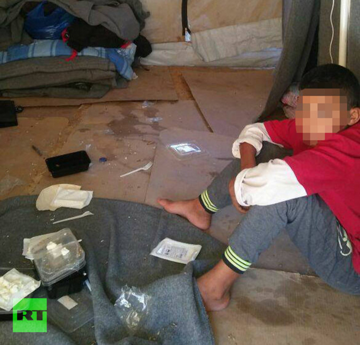  A young Syrian boy sits in the tent his five-year-old sister died in just hours earlier © RT