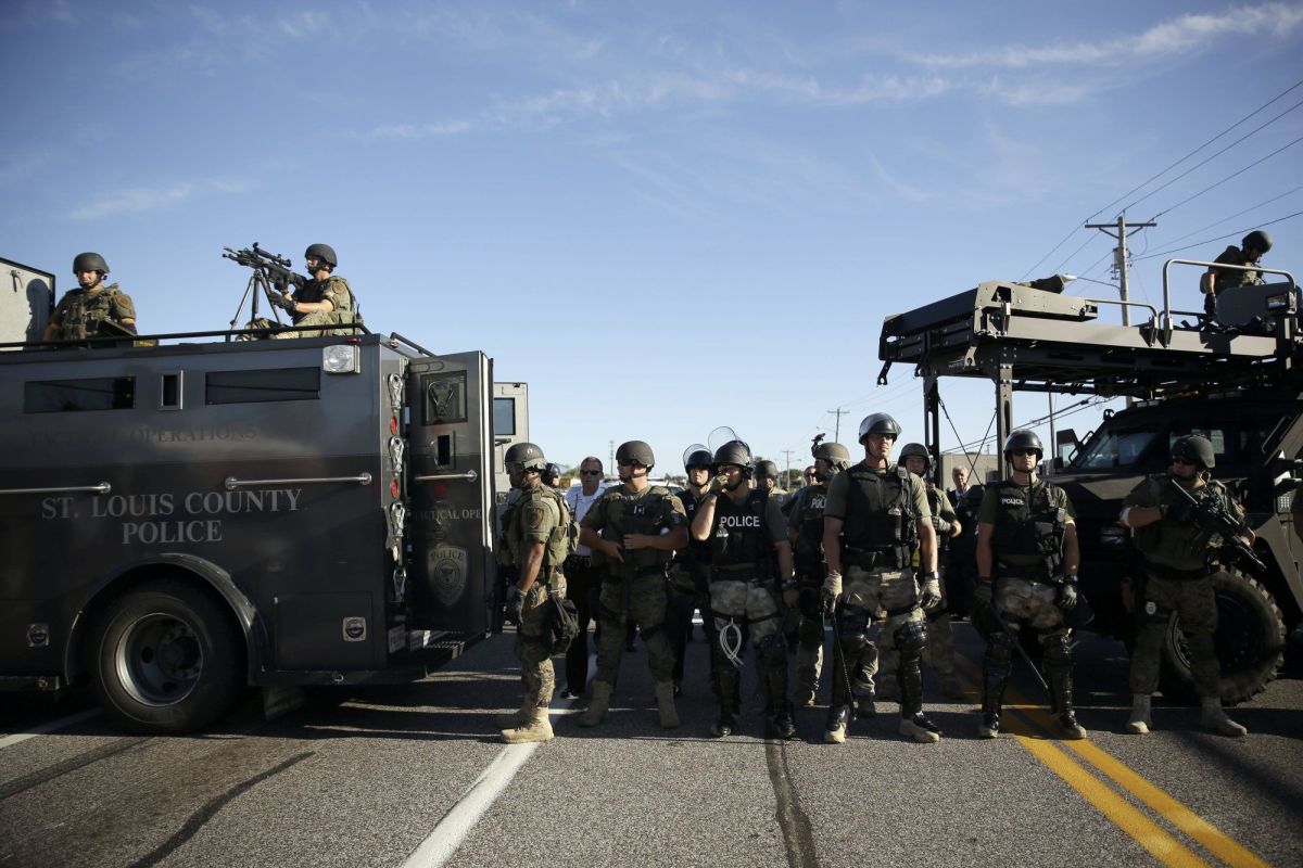 Police in riot gear watch protesters in Ferguson, Mo. on Aug. 13, 2014. Jeff Roberson—AP