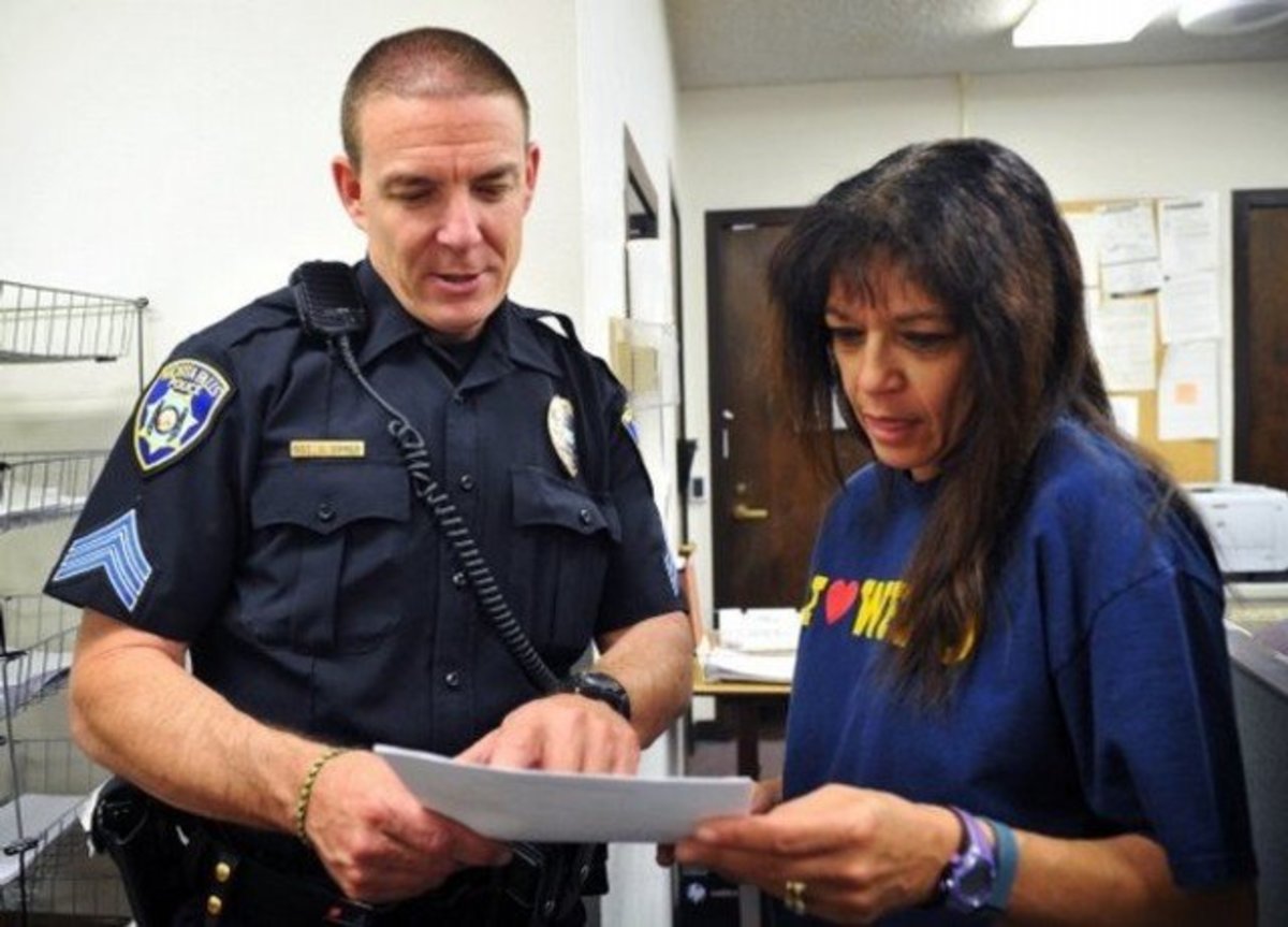 Sgt. Charlie Eipper turns in a report to records supervisor Alice Harrison during his shift as an officer for the Wichita Falls Police Department in Wichita Falls, Texas.  Image Credit: rtv6News