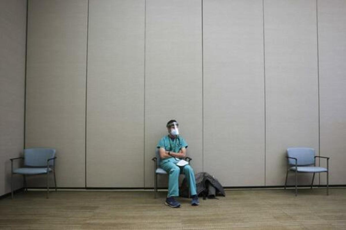 An internal medicine resident sits in a waiting area before receiving a dose of the Pfizer-BioNTech COVID-19 vaccine at a hospital in Aurora, Colorado, on Dec. 16, 2020. (Michael Ciaglo/Getty Images)
