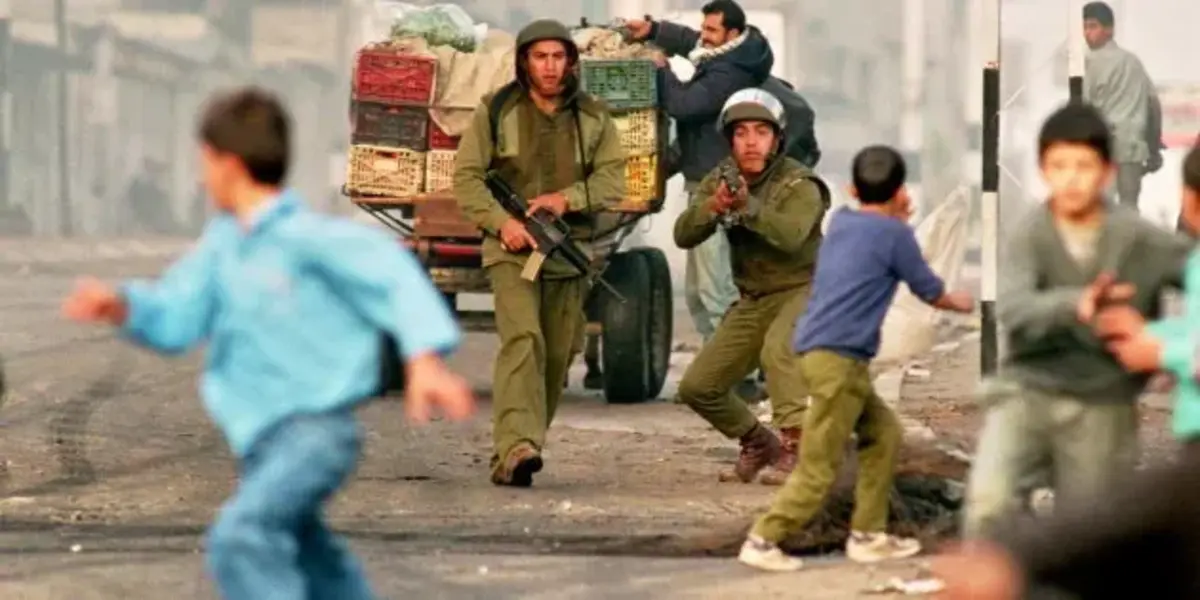 Israeli soldiers aim weapons at Palestinian children at the end of the first Intifada, Gaza city, November 1993. ― Source: Patrick BAZ/ AFP